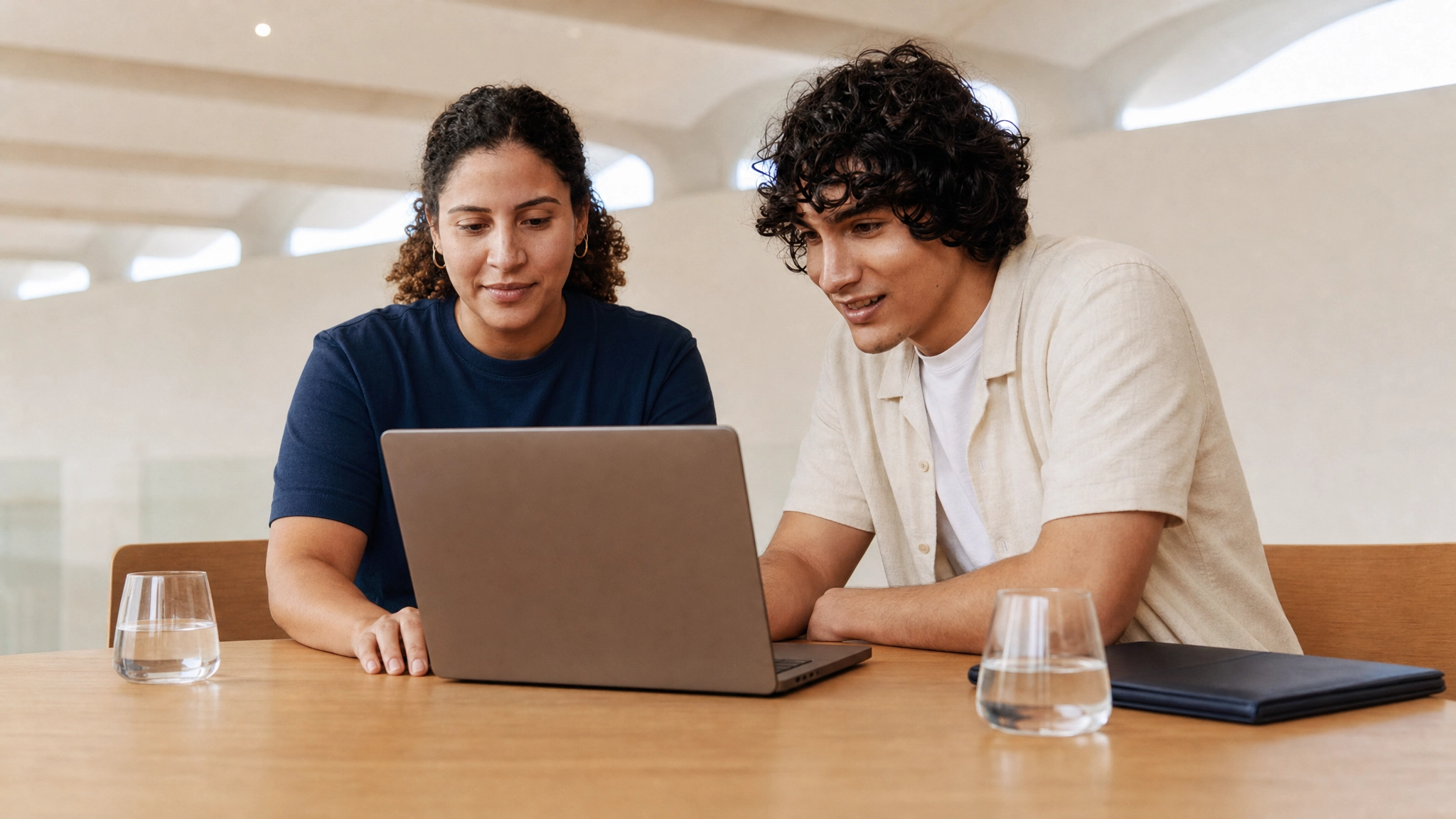 A client and specialist agreeing on project scope at a laptop.